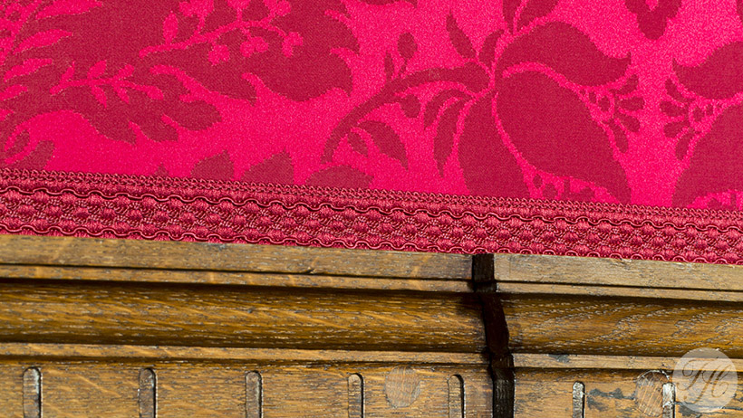 gespannen purperrode wandbespanning stof afwerkt met passend bandje