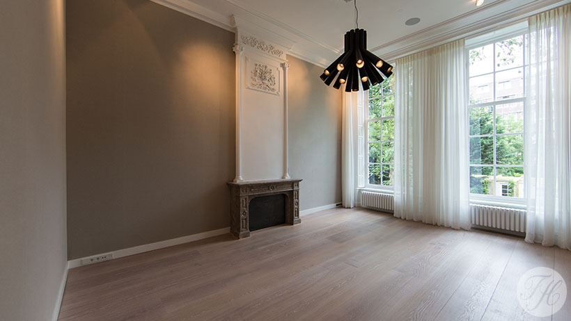 Muur bespannen met een effen stoffen wandbespanning en blind is afgewerkt